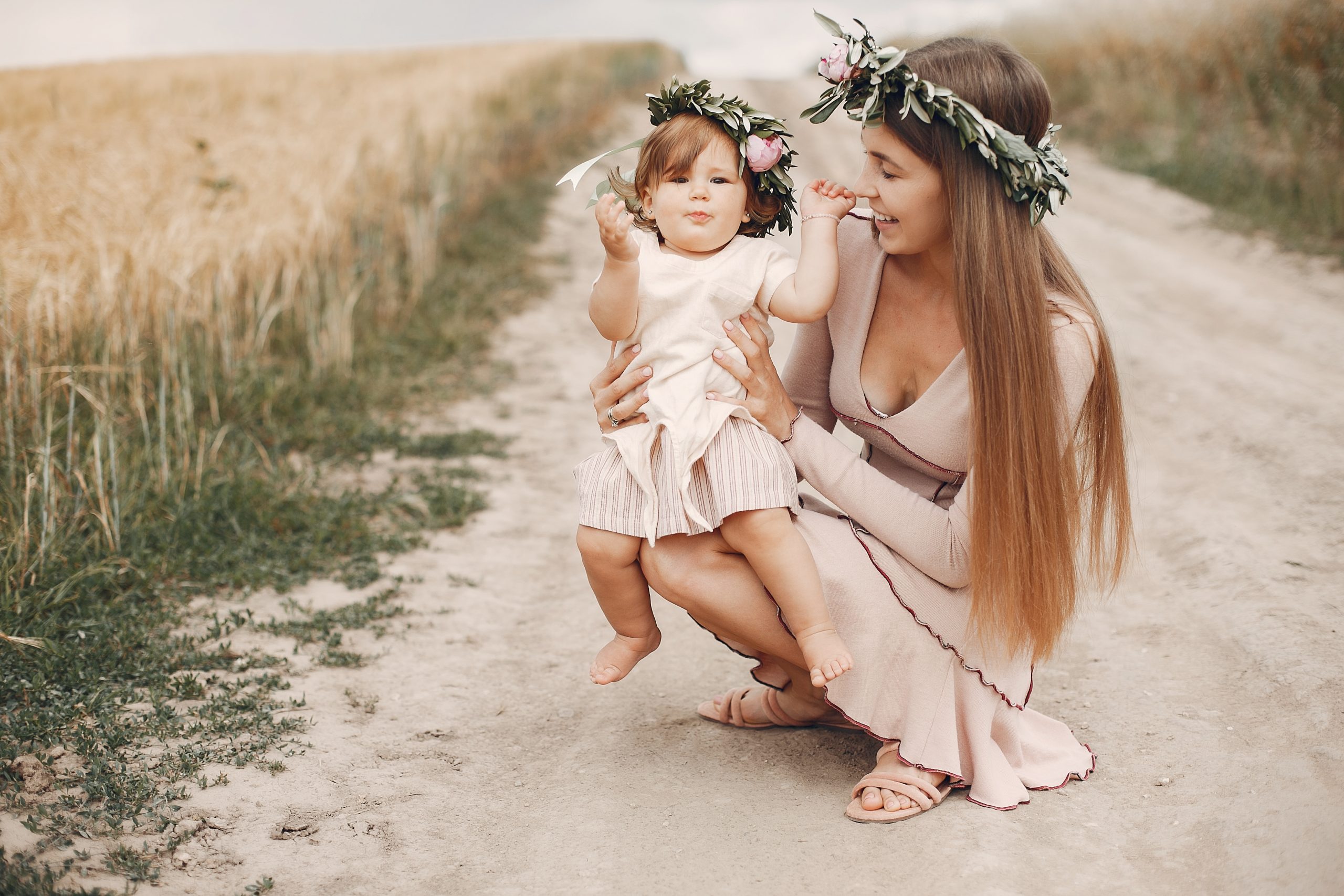 mother with daughter playing in a summer field